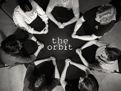 The Orbit improv cast performing in a circle at iO Theater Chicago